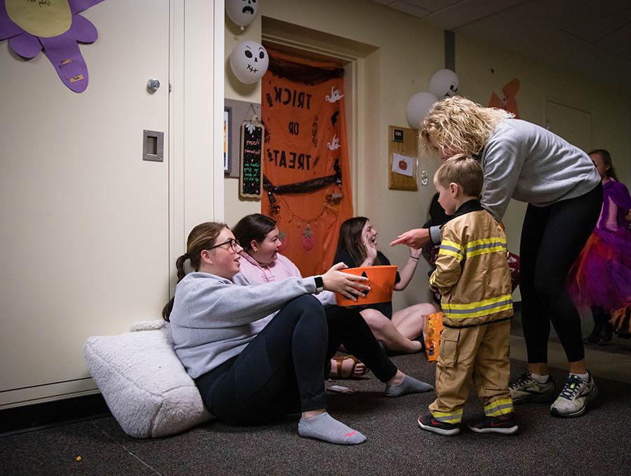 Northwest students greet families at the door of their residence hall room during last year's trick-or-treating event. (Northwest Missouri State University photo)  